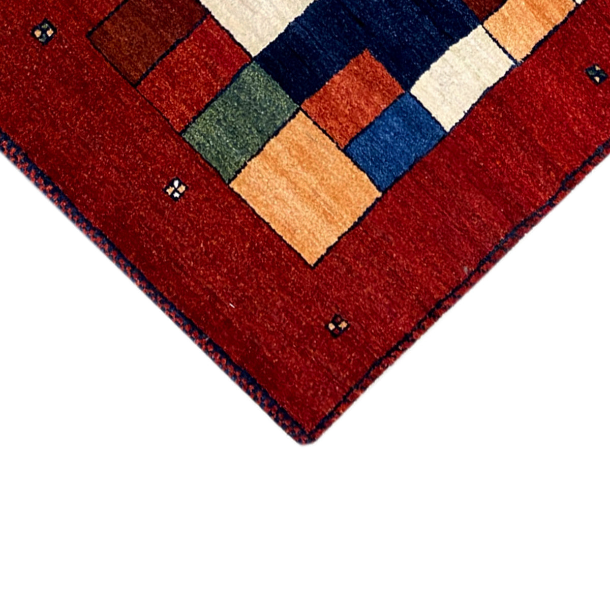 Corner view of the red carpet runner with a central geometric pattern and border.