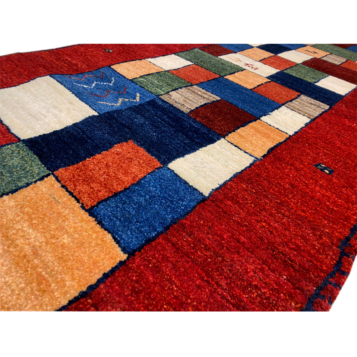 Close-up of the runner rug: red pile with a blue and orange tile pattern.