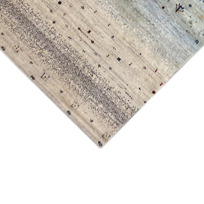 Corner view of Gabbeh rug: beige fabric with small dots and fine pattern lines