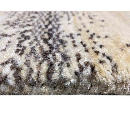 Carpet detail with a short pile and black and gray patterned spots on a beige background