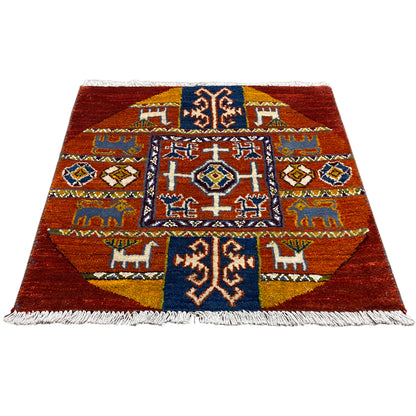 Gabbeh rug with a red background, medium-sized pattern and fringes, blue and white accents.