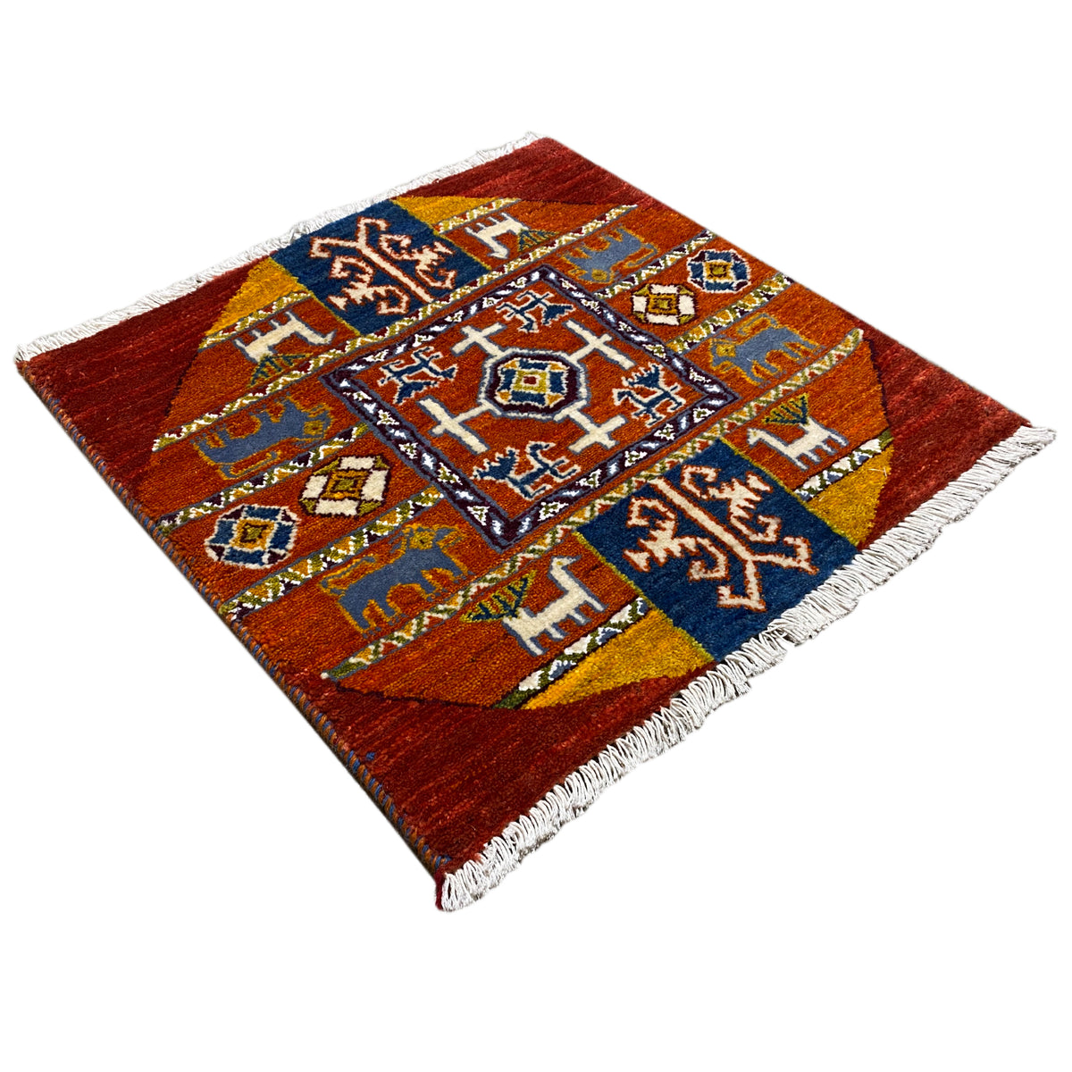 Gabbeh rug diagonal: red pattern with a blue central medallion and white fringes.