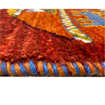 Gabbeh rug detail of the pile height and red fringes with blue stripes.