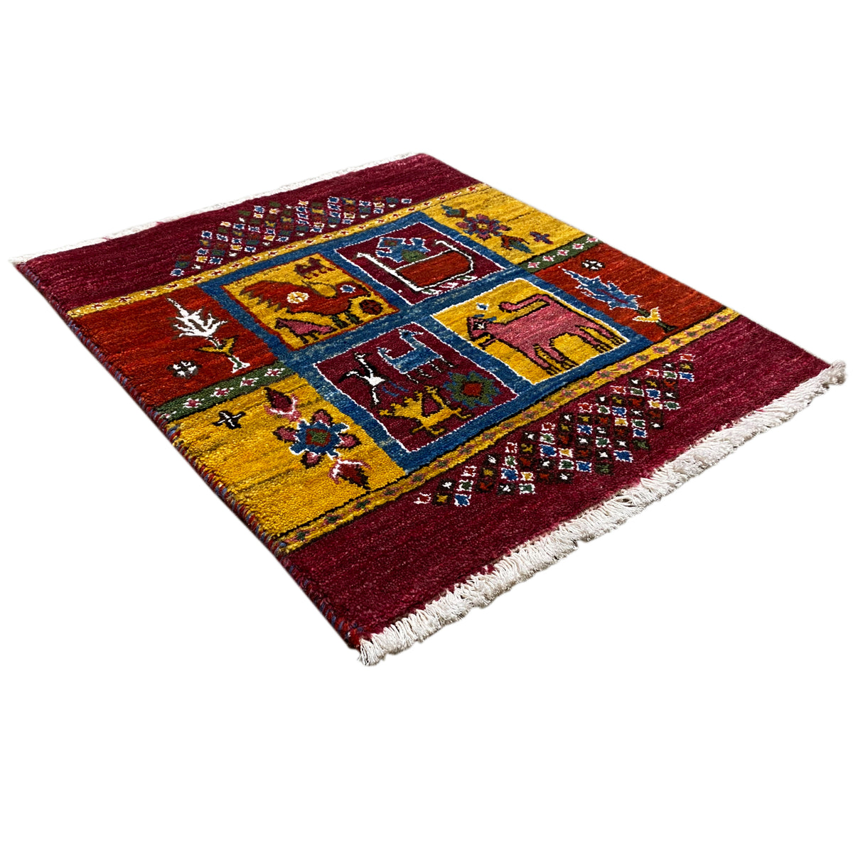 Gabbeh rug with a burgundy background and geometric pattern in blue, yellow, and turquoise, with fringes