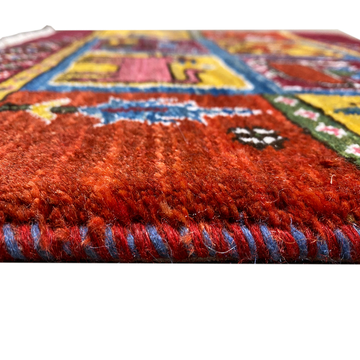 Gabbeh rug: dense wine-red pile, multicolored threads and border, fringes