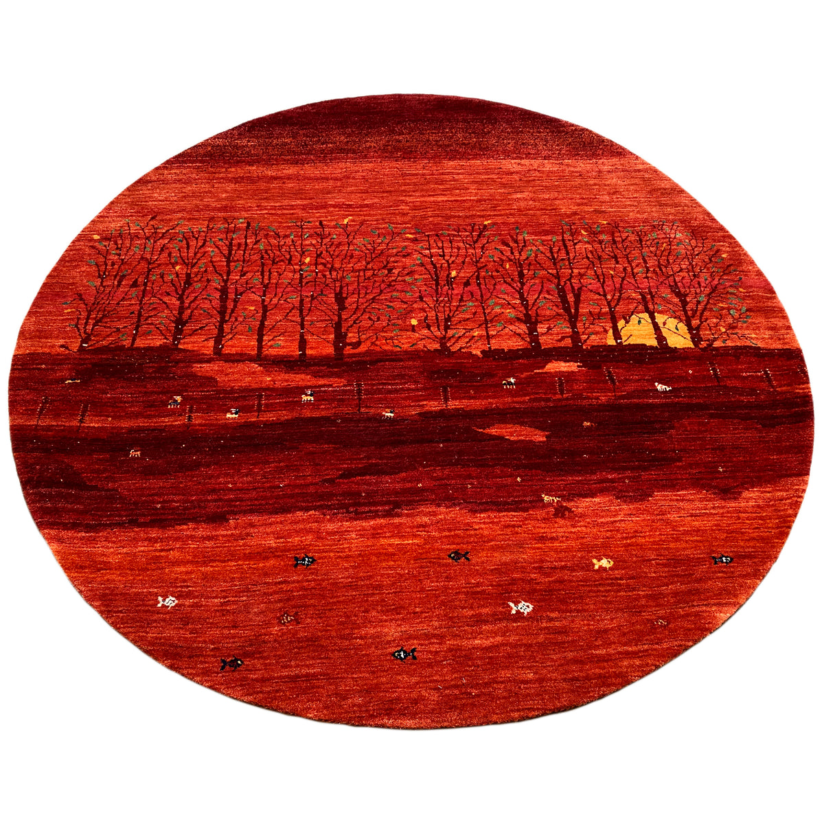 Round rug with a red landscape motif, dark rows of trees, and bright splashes of color
