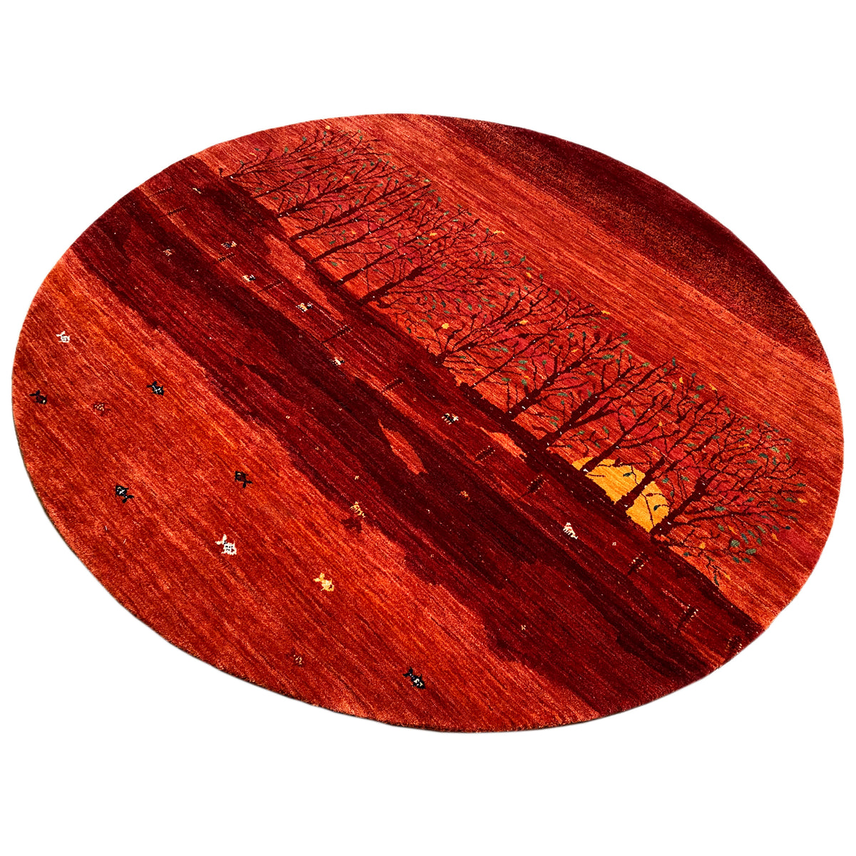 Round rug with a red landscape motif, a row of trees, and a colorful yellow element