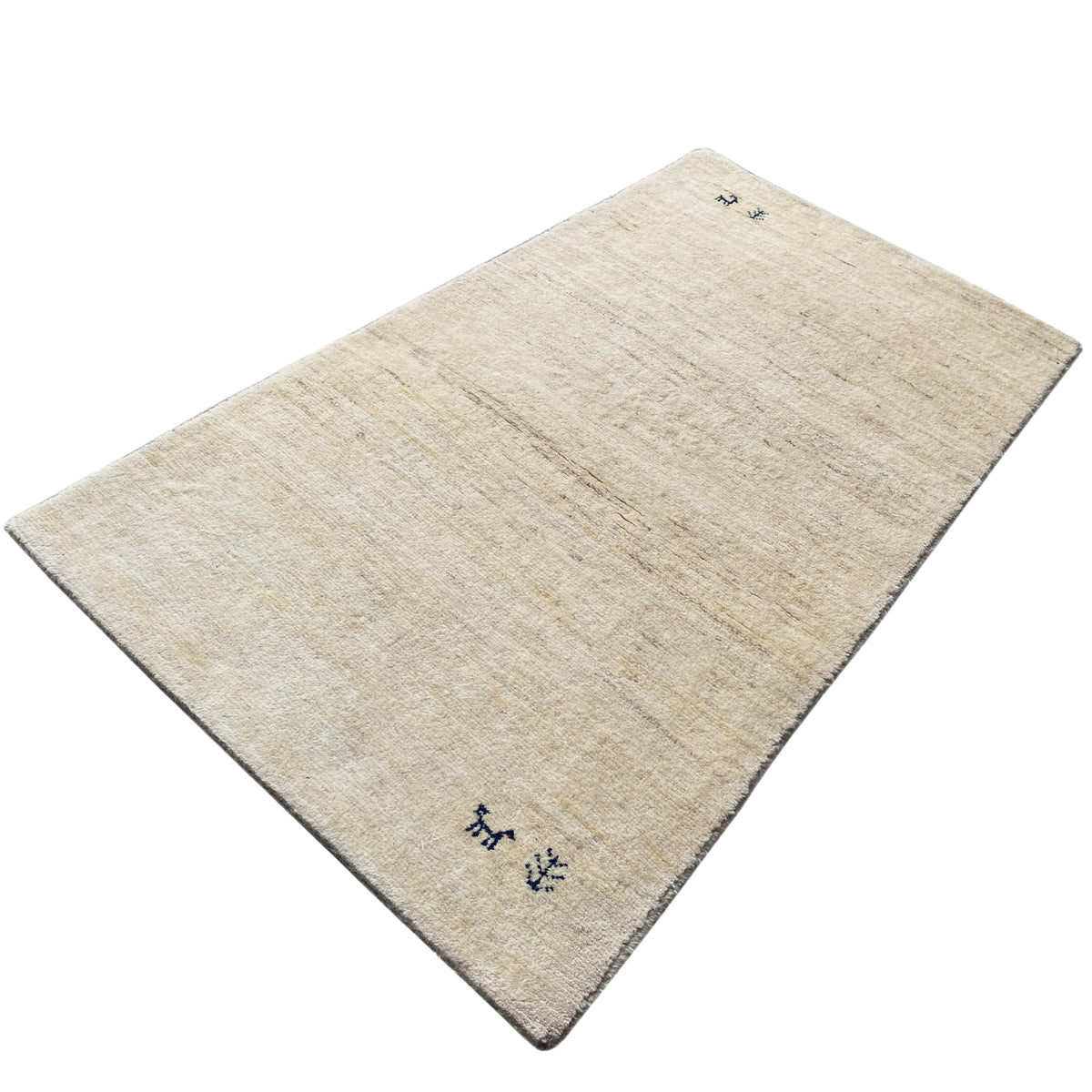 Gabbeh rug viewed diagonally, beige pile with dark blue animal and plant motifs