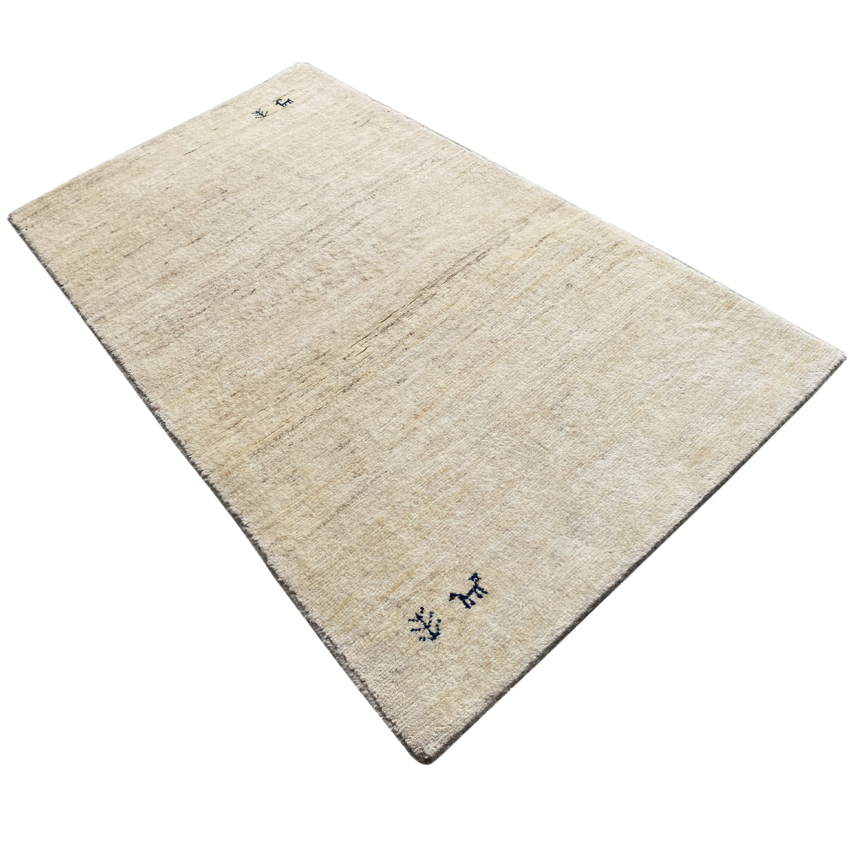Gabbeh rug viewed from above, light beige fabric with small dark blue embroideries in the corner