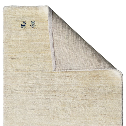 Gabbeh rug with visible backing, light beige pile, and sewn edge
