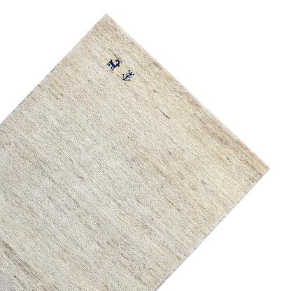 Gabbeh rug corner with a light beige pile and dark blue animal motifs