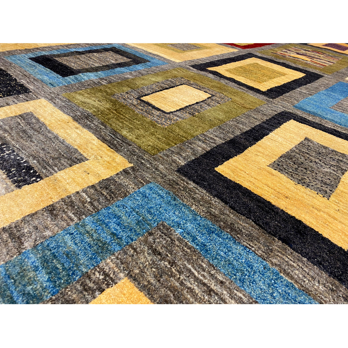 Rug detail with bold stripes and squares in gray, blue, yellow, and black