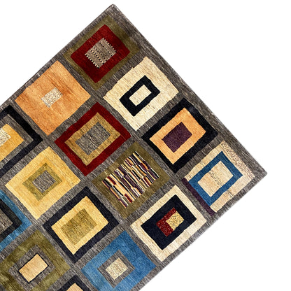 Carpet detail: geometric squares, gray with yellow, blue, and red accents