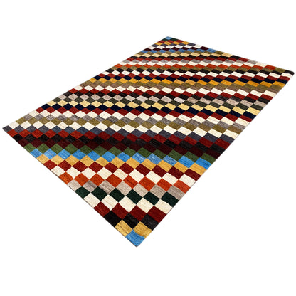 Gabbeh rug, photographed at an angle, with diamond and stripe patterns in vibrant colors.