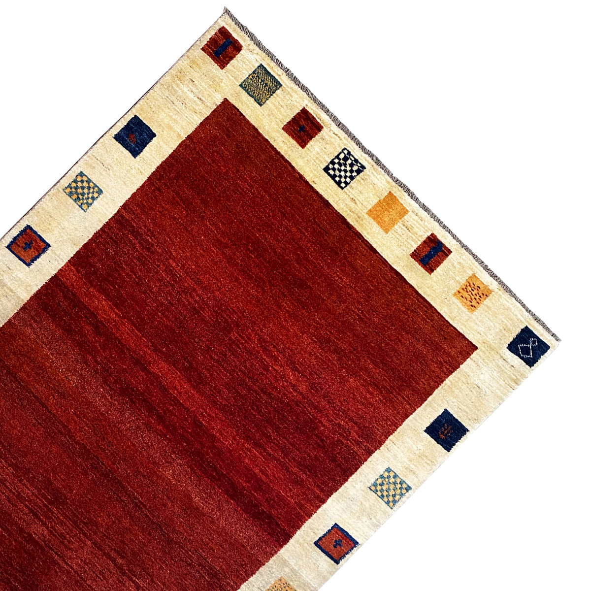 Gabbeh rug corner: red center, cream-colored border with dark blue and red tiles