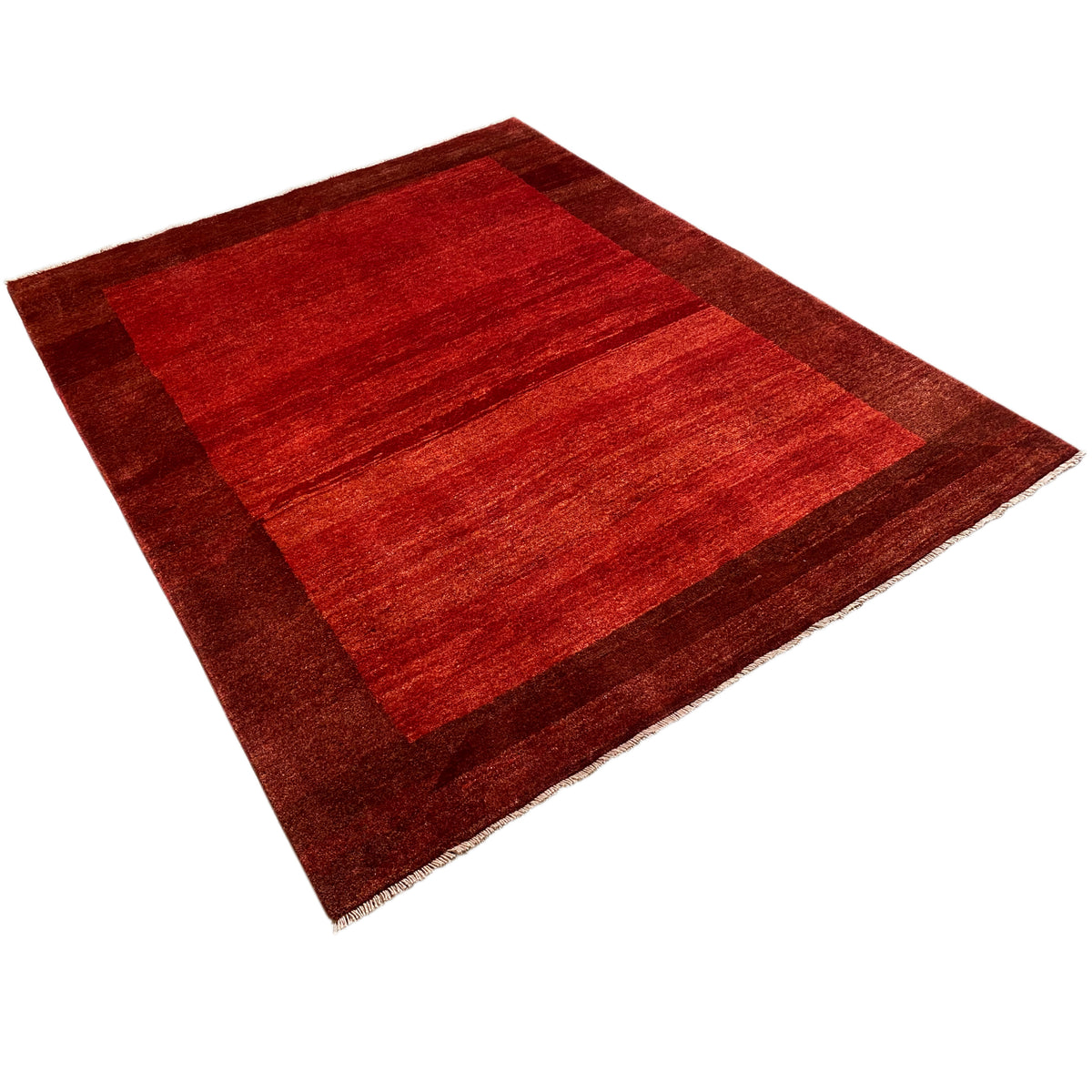 Red-brown striped Gabbeh rug with a wide border, photographed at an angle