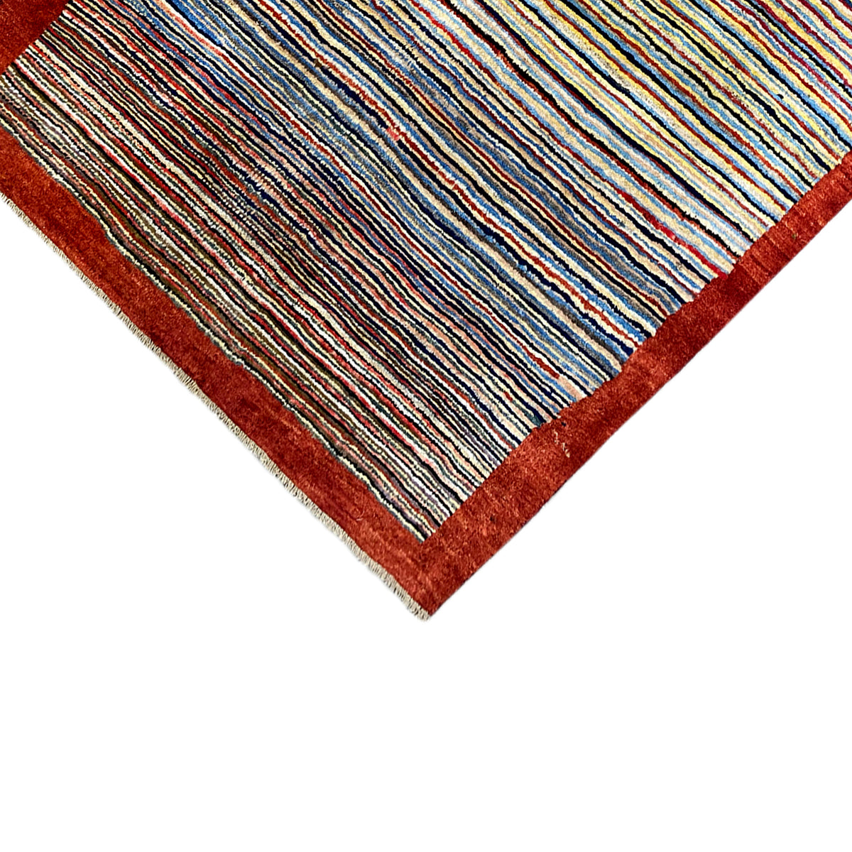 Carpet corner in detail: colorful stripes, dark red border, visible edge texture
