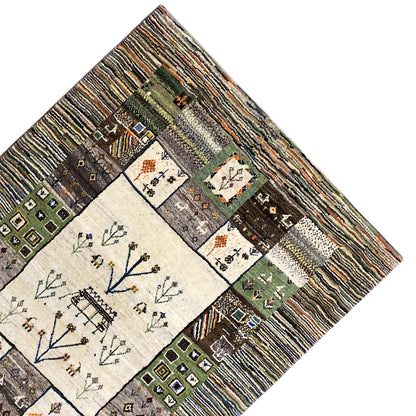 Gabbeh rug corner with border strips and a central field featuring a tree and house motif