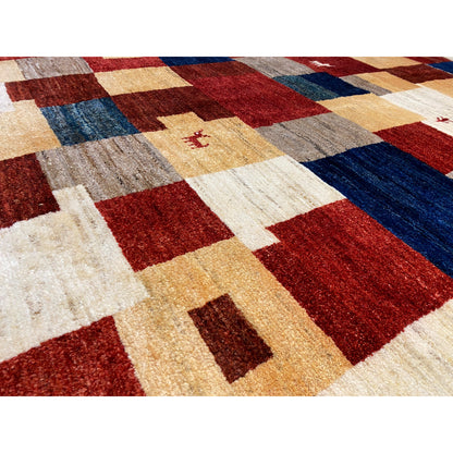 Gabbeh rug detail: patterned squares, curly pile texture in red, blue, and cream