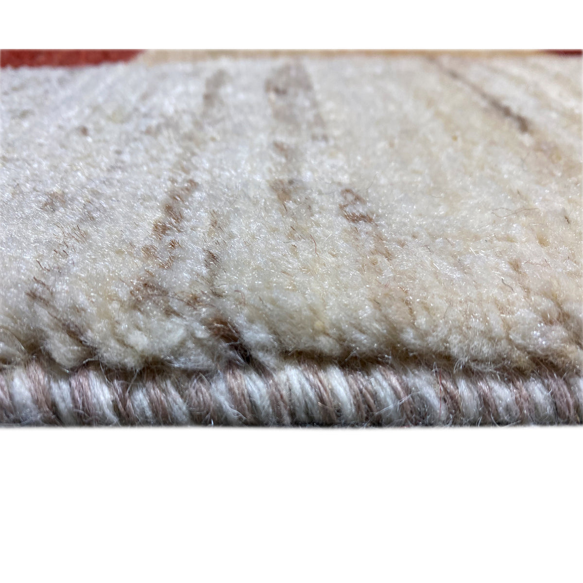 Gabbeh rug close-up of the pile: dense, fluffy beige with a short shadowy sheen
