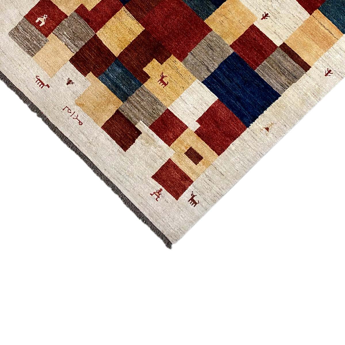 Gabbeh rug corner with fringed edges, square pattern in cream, red and dark blue