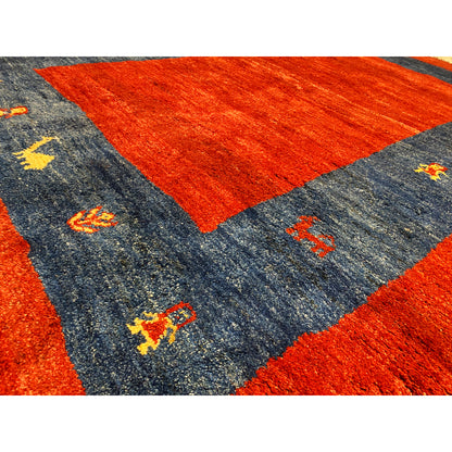 Close-up of Gabbeh rug: red central section, gray-blue border, and colorful small animals