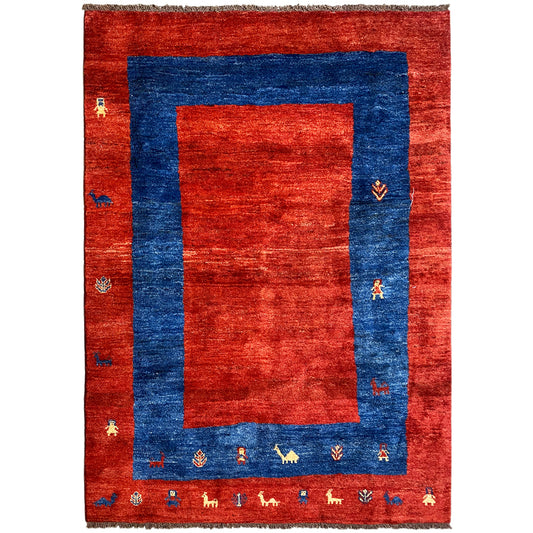Gabbeh rug with a red background and blue border, intricate patterns and decorative edging