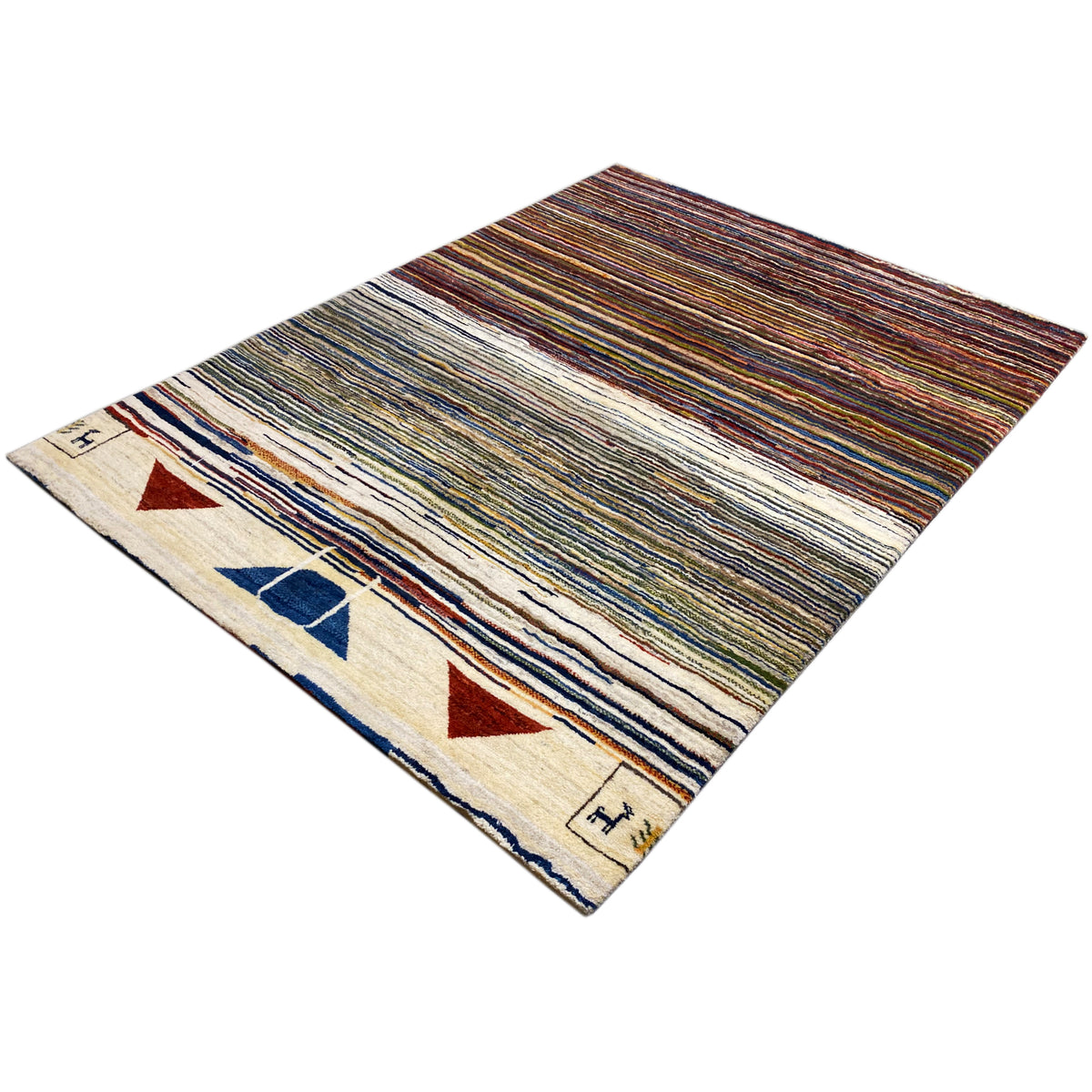 Gabbeh rug photographed at an angle: striped design with triangles and block motifs