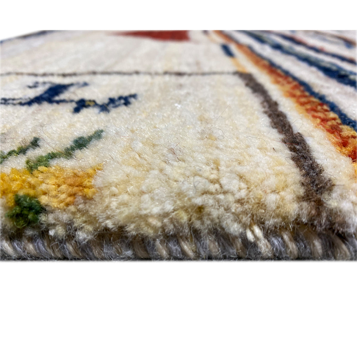Close-up of a Gabbeh rug: soft, fluffy surface with worn color transitions