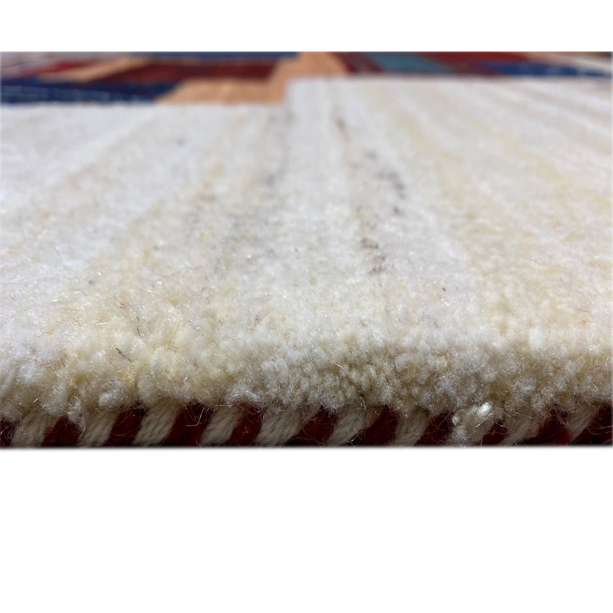 Gabbeh rug close-up of the pile: soft, light texture on a beige background