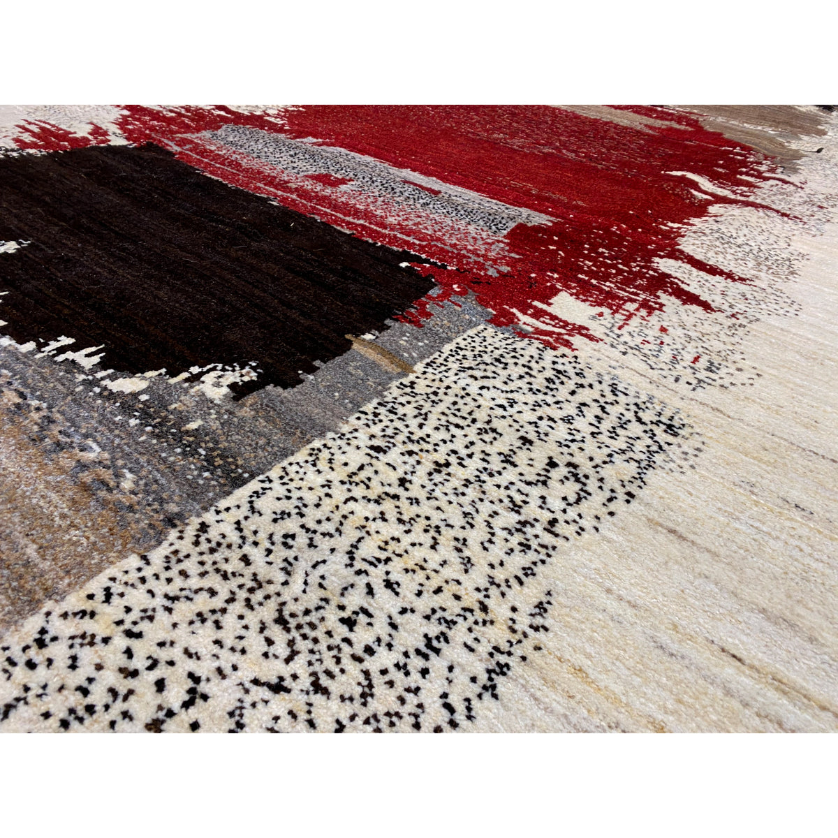 Gabbeh rug close-up: speckled texture with red and black motifs on light beige