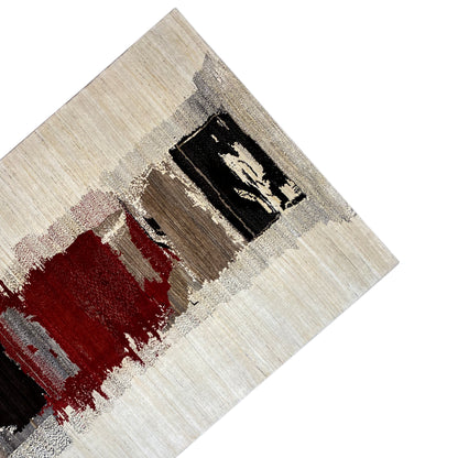 Gabbeh rug detail from the corner: black field with red accents on light beige