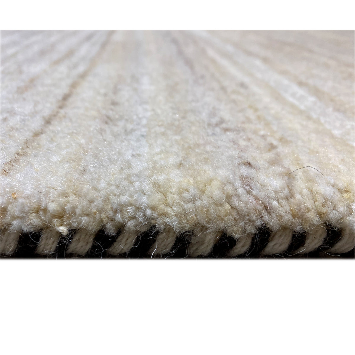 Gabbeh rug close-up of the pile edge: beige fabric with a dark underside
