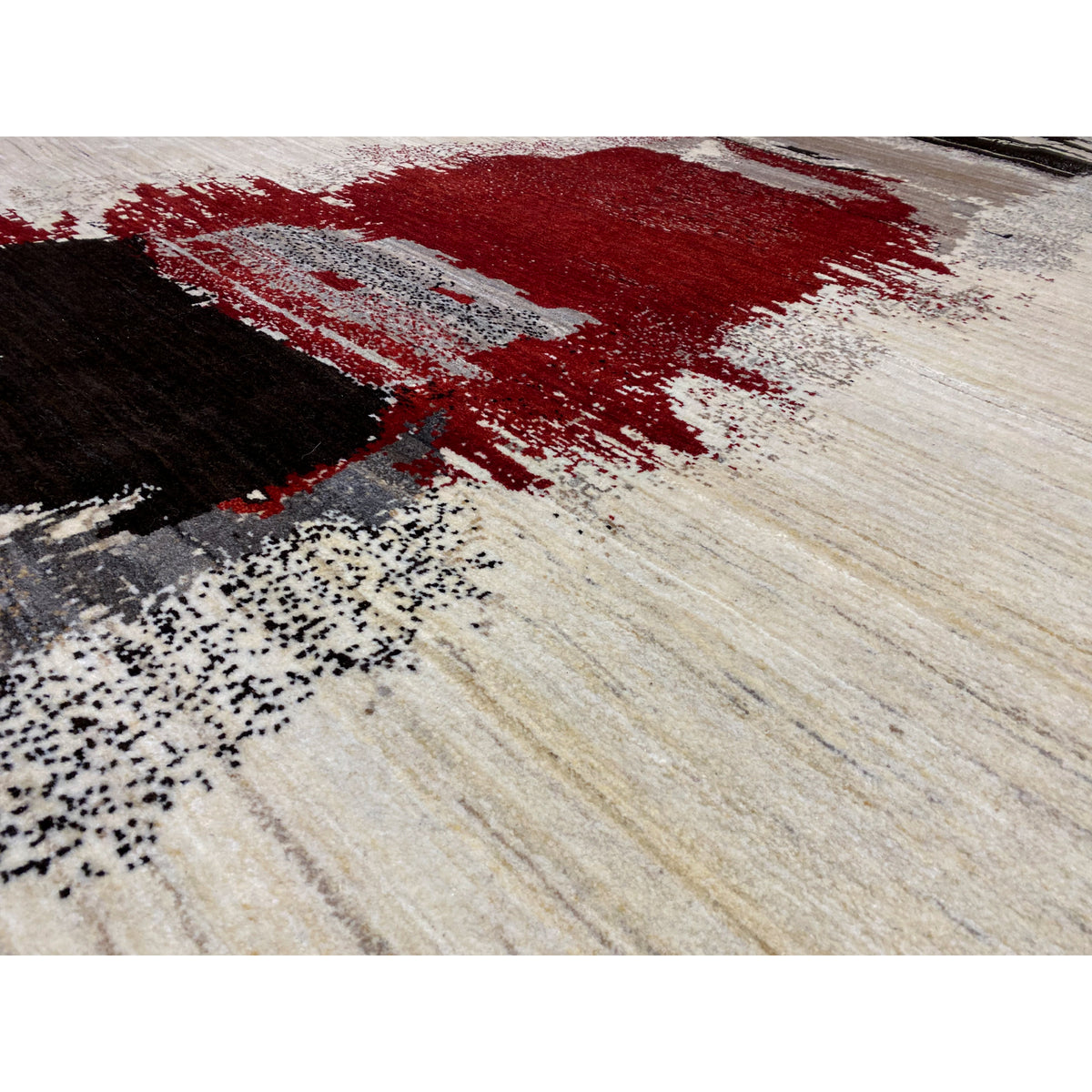 Close-up: Rug with red and black color blocks on a beige, textured background