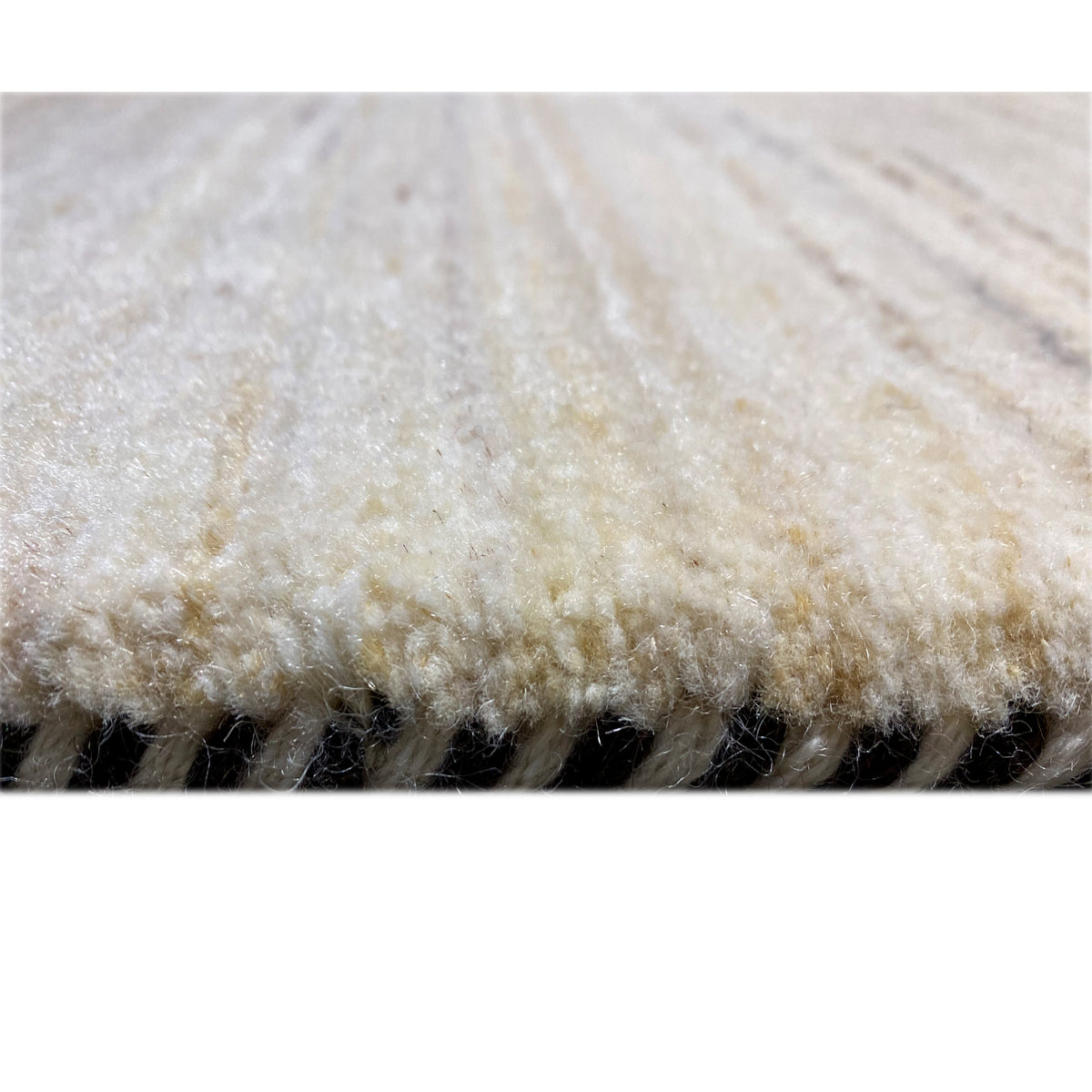 Carpet detail with beige pile and a dark seam along the edge