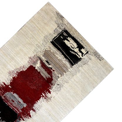 Carpet detail with a red stain and black rectangular pattern on a beige background