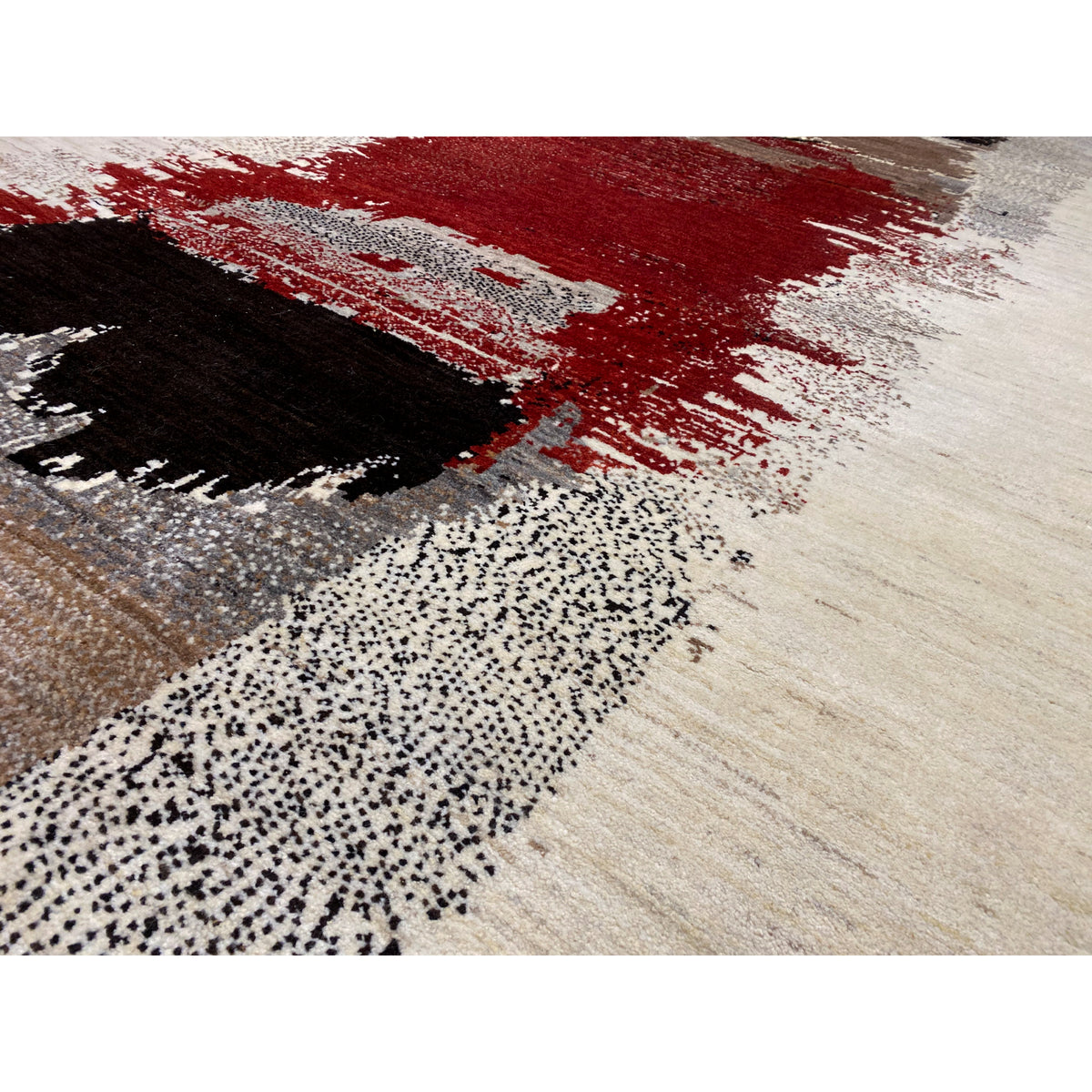 Gabbeh rug close-up: light fiber texture with red, black, and gray sections