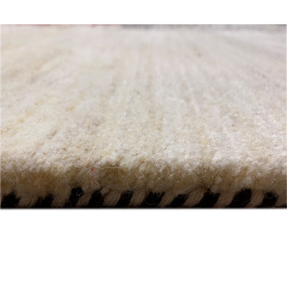 Gabbeh rug close-up: light fibers with a dark border along the edge