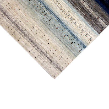 Gabbeh rug with fine vertical and horizontal stripes in cream and blue, photographed at an angle