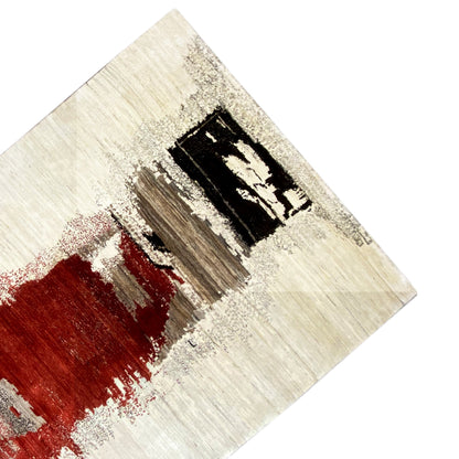 Gabbeh rug detail with a red color spot, beige-gray background, and black diamonds