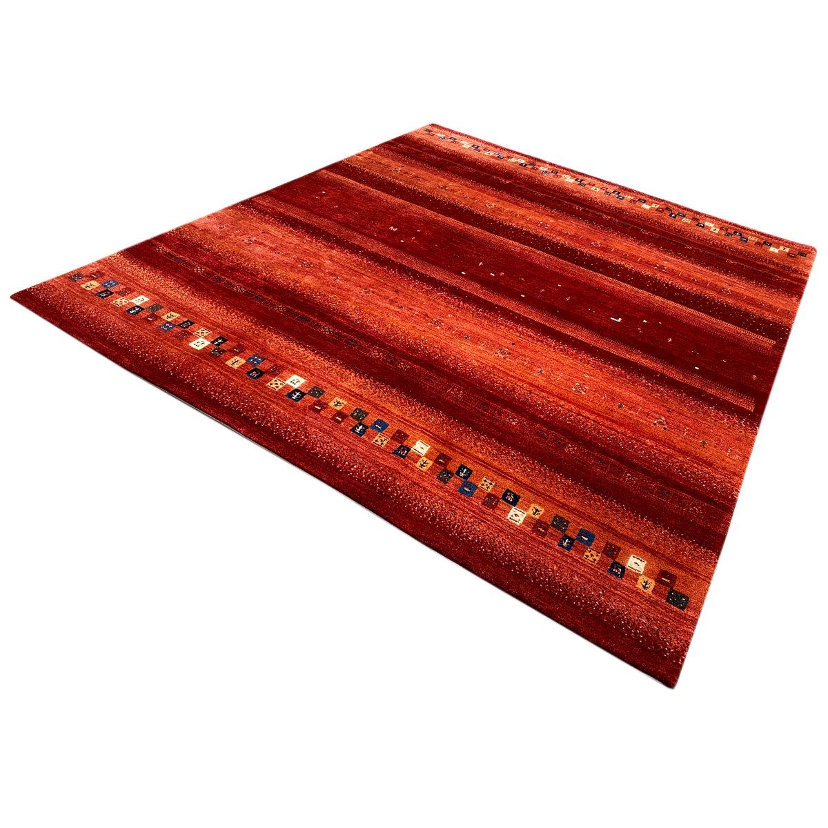 Red Gabbeh rug at an angle, with stripes and a colorful border along the edge