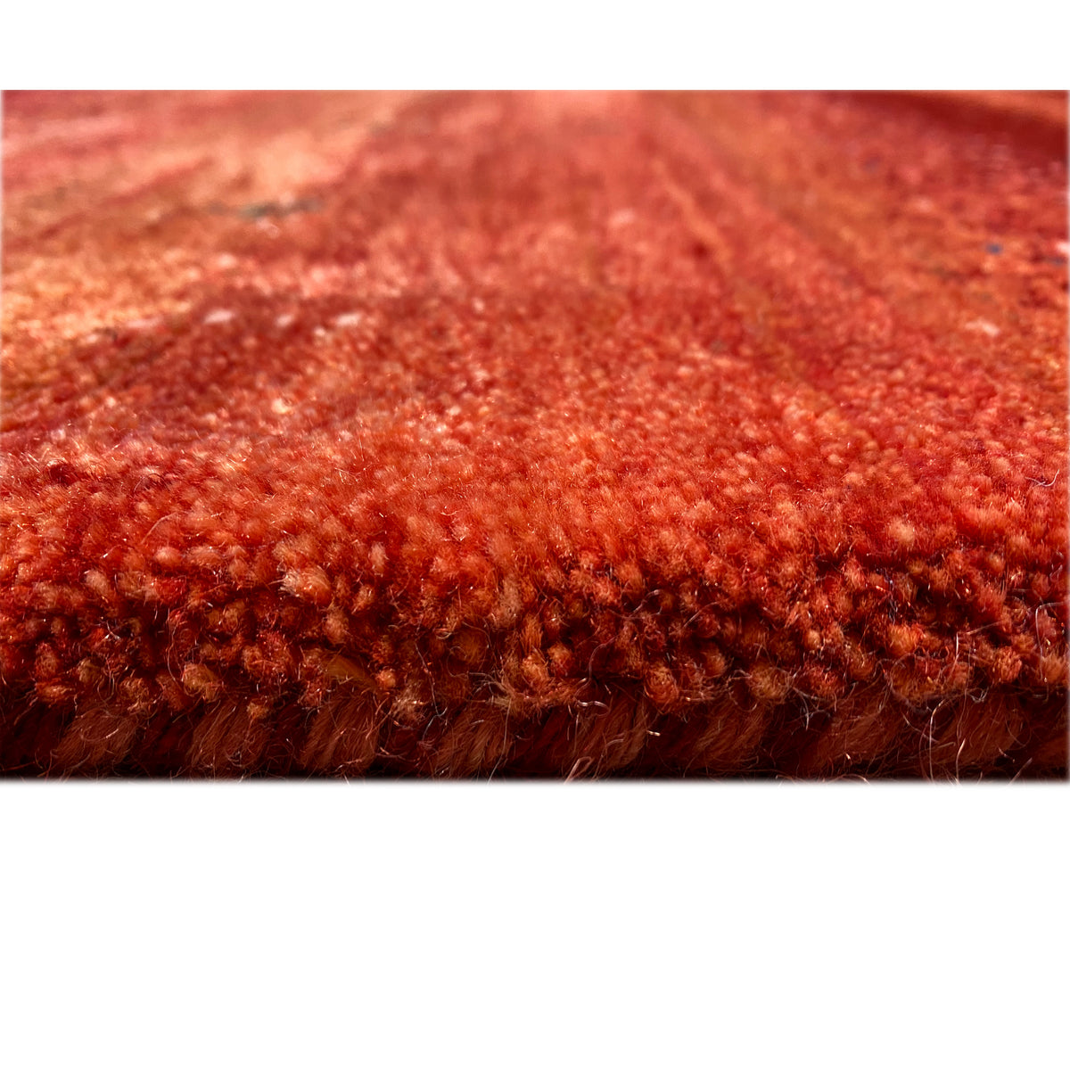 Close-up of the pile: red Gabbeh rug with a dense, high-pile weave structure