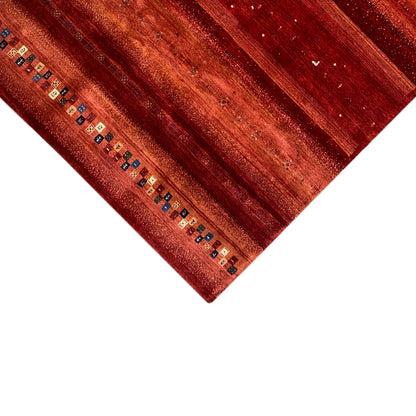 Corner in detail: red Gabbeh rug with border and multicolored squares