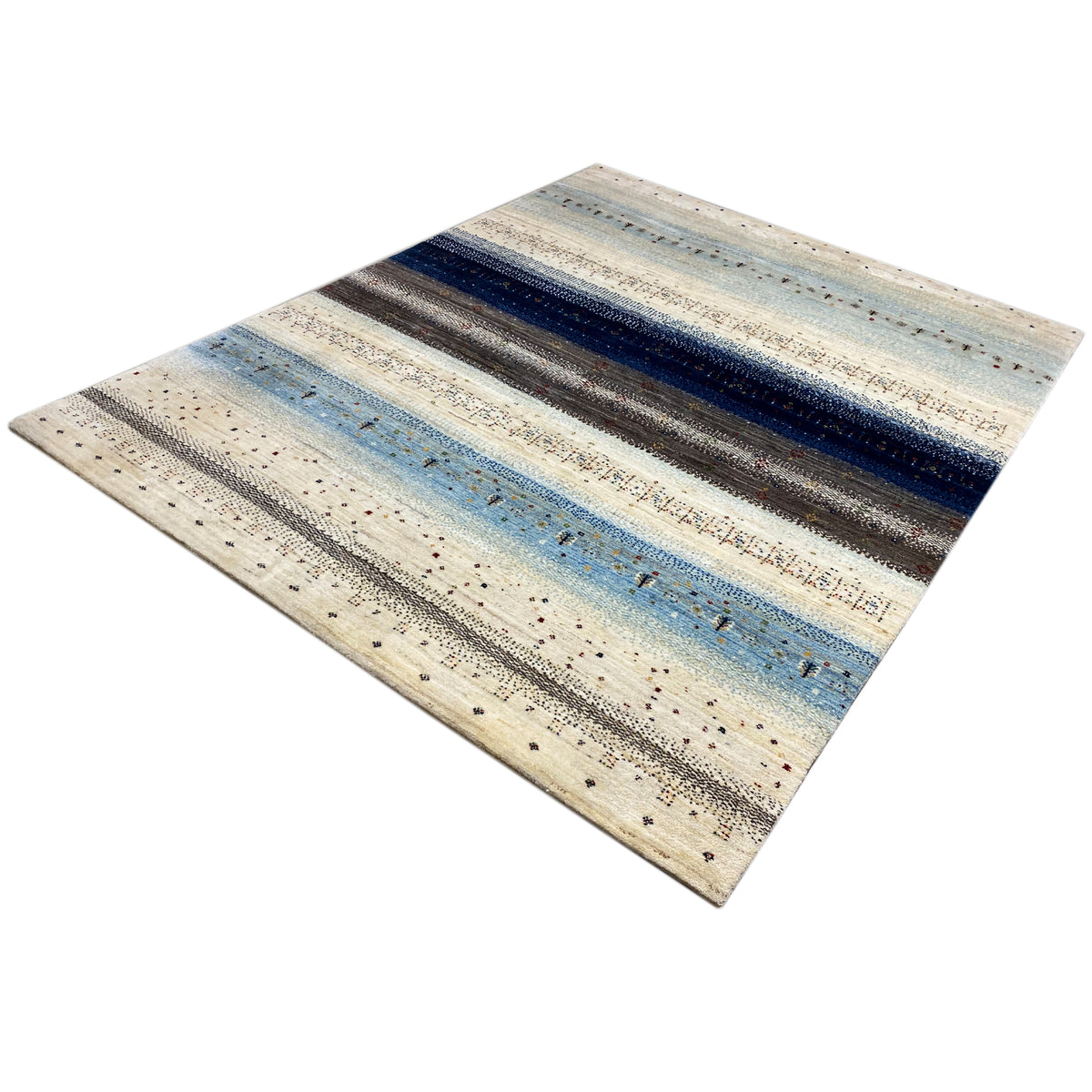 Rug with a diagonal design: cream, light blue, and dark speckled stripes