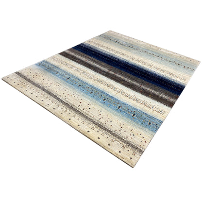 Rug with a diagonal design: cream, light blue, and dark speckled stripes