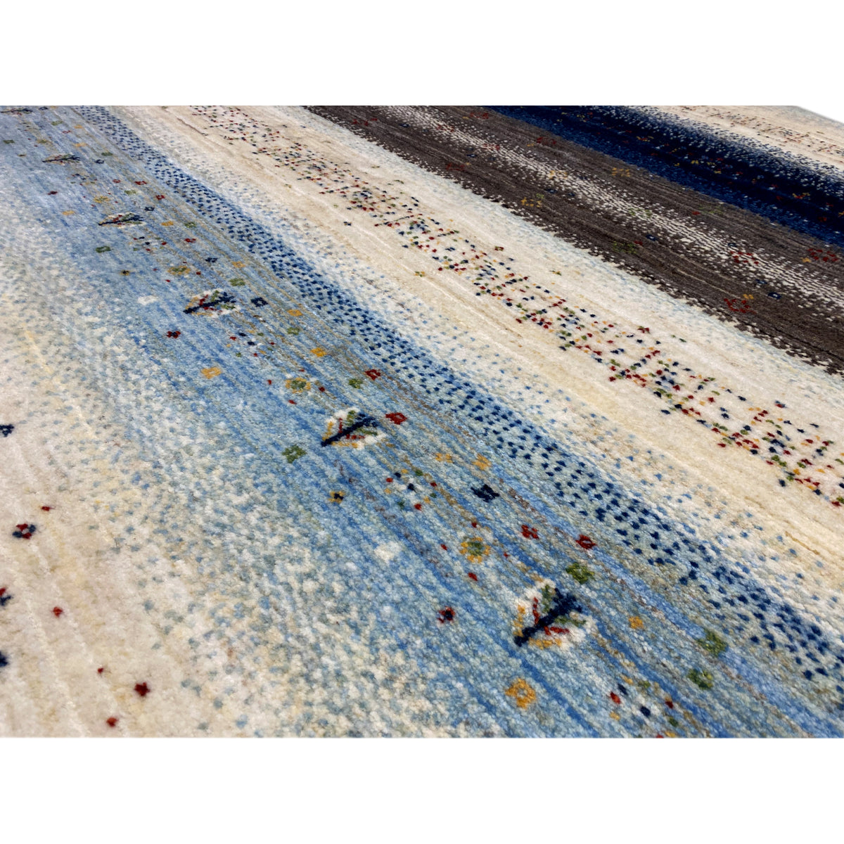 Close-up: needle pattern with a blue background, cream-colored areas, and colorful speckles