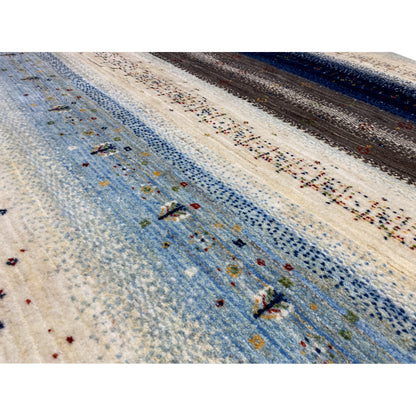 Close-up: needle pattern with a blue background, cream-colored areas, and colorful speckles