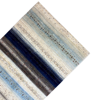 Rug viewed from above: light cream and pale blue stripes, with dark band patterns in between