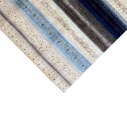 Gabbeh rug in three-quarter view with narrow stripes and fine speckled color dots