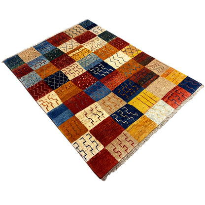 Gabbeh rug in an angled view, square patchwork fields with zigzag and diamond patterns